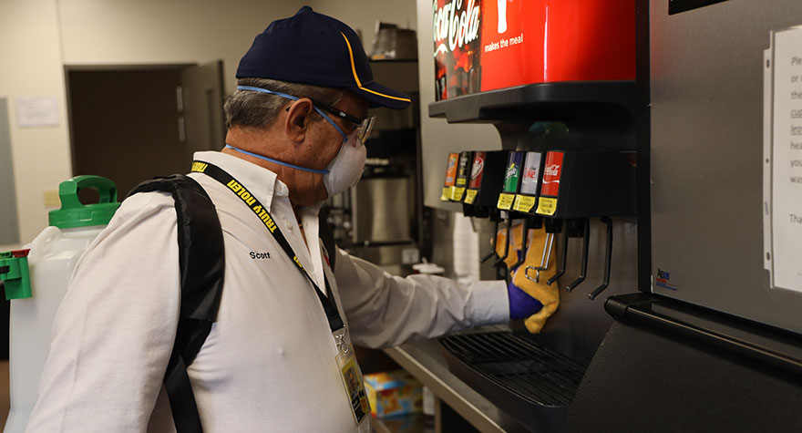 Wiping Soda Machine with Sanitizing Wipe