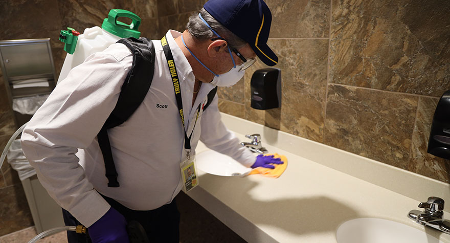 Wiping Bathroom Sink Counter with Sanitizing Wipe