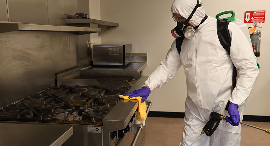 Wiping Industrial Stove with Sanitizing Wipe