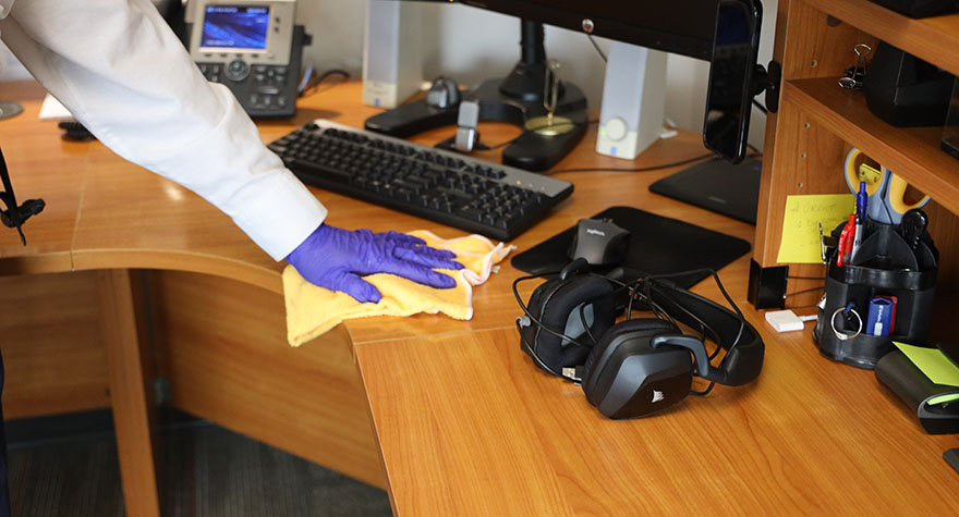 Wiping Office Desk with Sanitizing Wipe