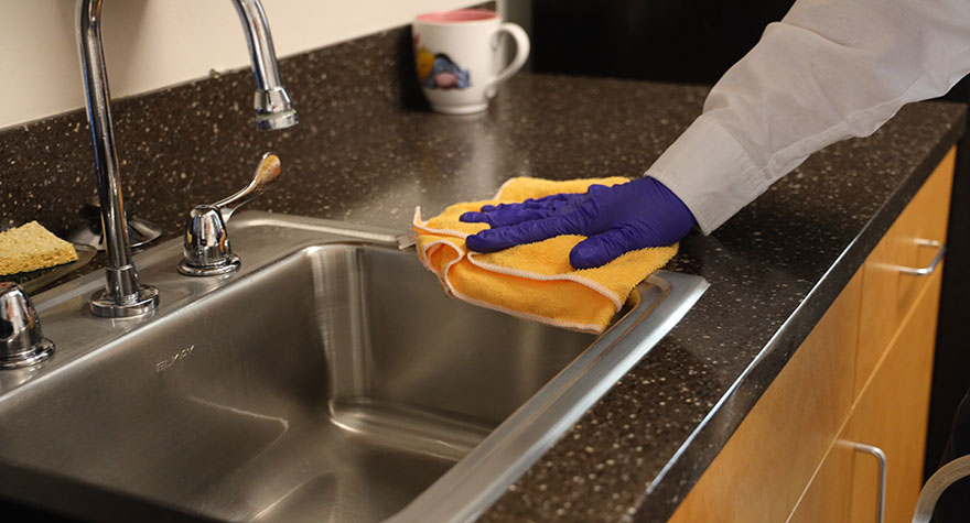 Wiping Kitchen Sink with Sanitizing Wipe