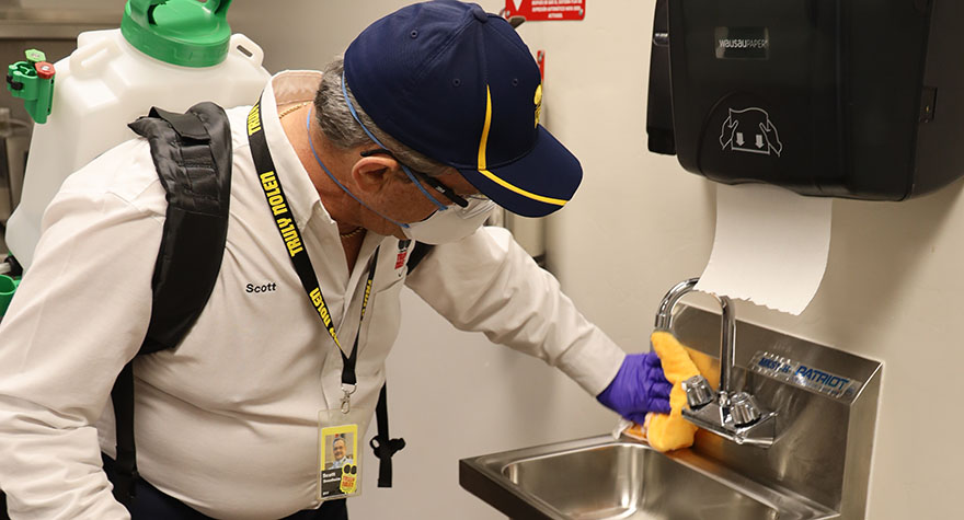 Wiping Industrial Sink with Sanitizing Wipe
